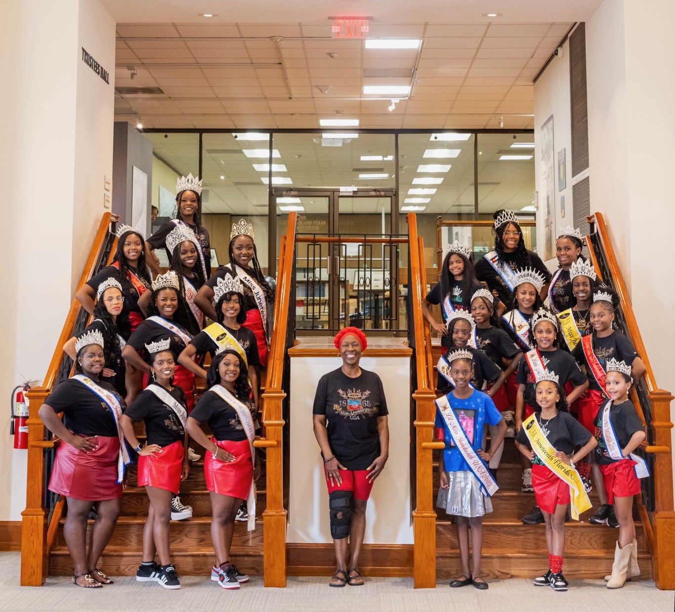 Miss Juneteenth USA queens and leadership on the staircase at Trustees Hall